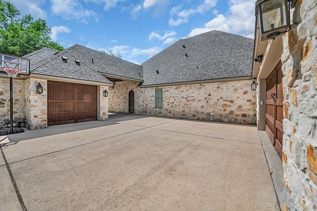 8416 Spicewood Springs Rd, Waco, TX 76633 - view of front of home with stone siding, concrete driveway, a garage, and a shingled roof