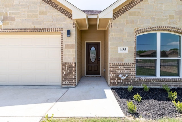 1435 Vine St, Weatherford, TX 76086 - view of exterior entry featuring an attached garage, brick siding, and concrete driveway
