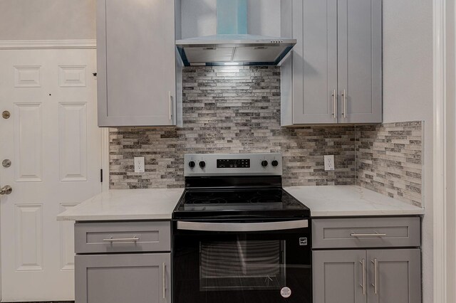 1435 Vine St, Weatherford, TX 76086 - kitchen with stainless steel range with electric cooktop, wall chimney range hood, gray cabinetry, backsplash, and light stone counters