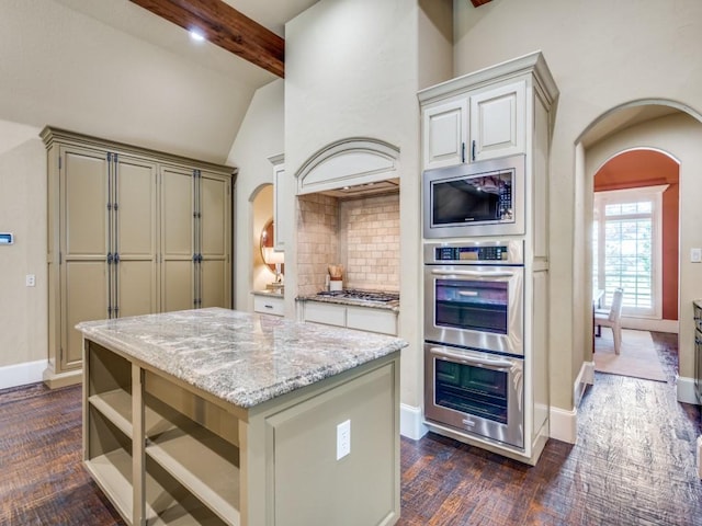 3917 W 6th St, Fort Worth, TX 76107 - kitchen featuring stainless steel appliances, arched walkways, decorative backsplash, light stone countertops, and baseboards