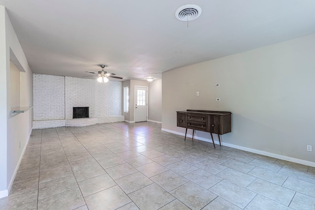 2218 Archer Trl, Denton, TX 76209 - unfurnished living room with ceiling fan, a fireplace, light tile patterned flooring, baseboards, and brick wall