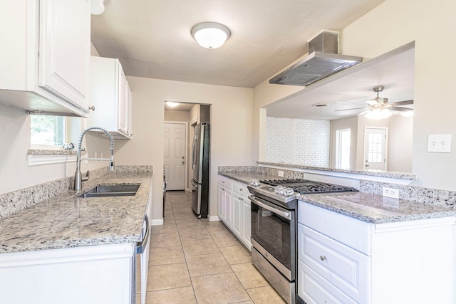 2218 Archer Trl, Denton, TX 76209 - kitchen featuring appliances with stainless steel finishes, a sink, wall chimney range hood, white cabinets, and ceiling fan