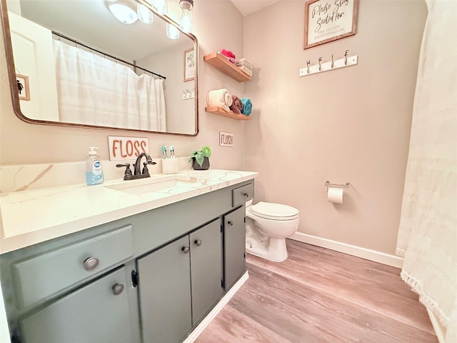 108 Martha Dr, Winnsboro, TX 75494 - bathroom with wood finished floors, toilet, vanity, and baseboards