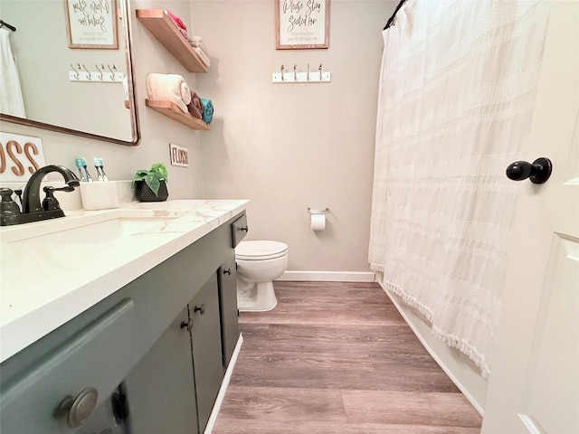 108 Martha Dr, Winnsboro, TX 75494 - bathroom with vanity, toilet, wood finished floors, baseboards, and a shower with shower curtain