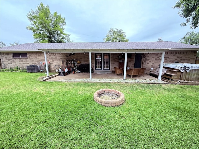 108 Martha Dr, Winnsboro, TX 75494 - rear view of house featuring central air condition unit, a patio area, brick siding, a lawn, and roof with shingles