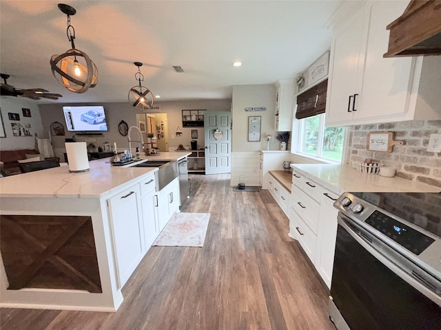 108 Martha Dr, Winnsboro, TX 75494 - kitchen with appliances with stainless steel finishes, wood finished floors, open floor plan, a sink, and hanging light fixtures
