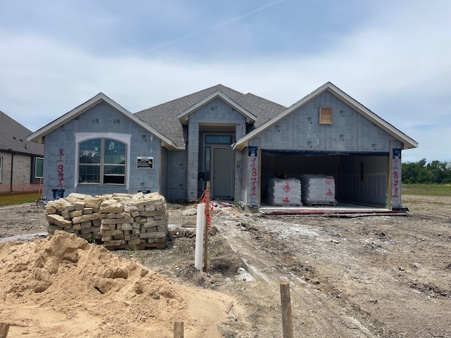property in mid-construction featuring a shingled roof, a garage, and dirt driveway