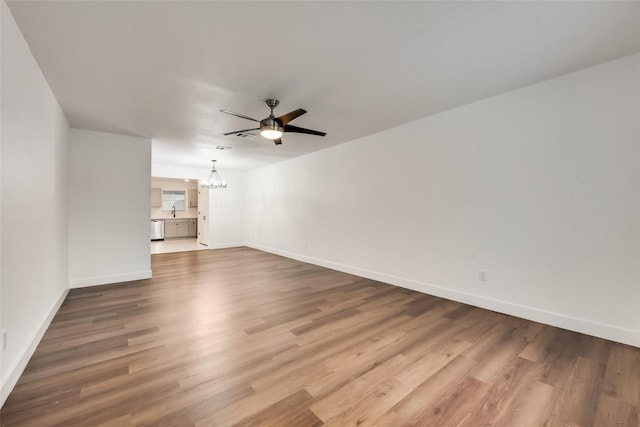 4900 S Drive, Fort Worth, TX 76132 - unfurnished living room with a chandelier, wood finished floors, ceiling fan, baseboards, and a sink