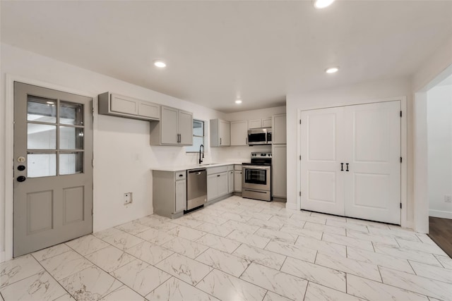 4900 S Drive, Fort Worth, TX 76132 - kitchen featuring stainless steel appliances, gray cabinetry, a sink, light countertops, and light marble finish floors