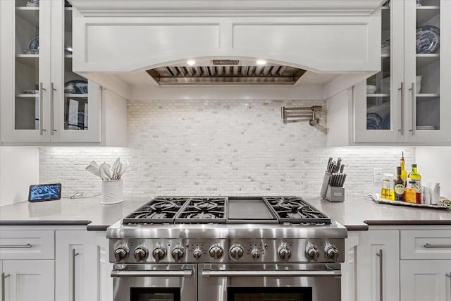 10031 Tumbling Trl, Waco, TX 76657 - kitchen with range with two ovens, white cabinets, tasteful backsplash, and glass insert cabinets