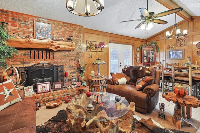 living room featuring a textured ceiling, ceiling fan, a brick fireplace, a chandelier, and wood walls