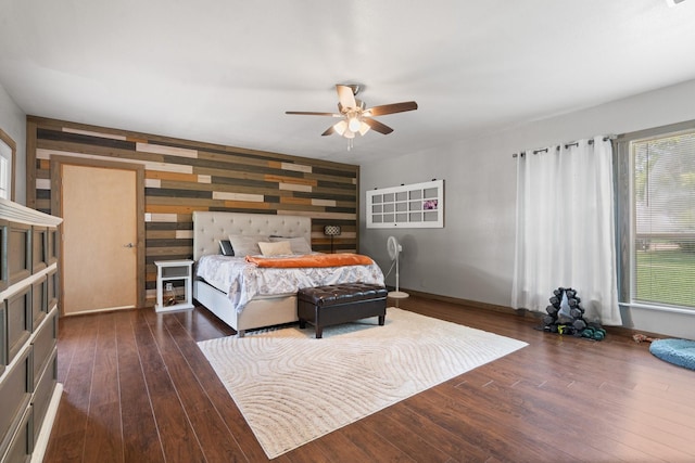 11240 County Road 102, Grandview, TX 76050 - bedroom with an accent wall, wood finished floors, wood walls, baseboards, and a ceiling fan