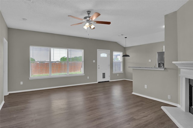 2532 Nogales Dr, Fort Worth, TX 76108 - unfurnished living room with a ceiling fan, dark wood-type flooring, a fireplace with raised hearth, baseboards, and lofted ceiling