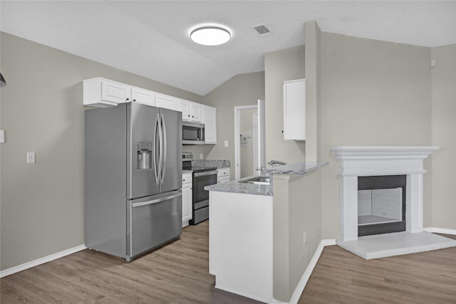 2532 Nogales Dr, Fort Worth, TX 76108 - kitchen featuring appliances with stainless steel finishes, wood finished floors, white cabinetry, a peninsula, and baseboards
