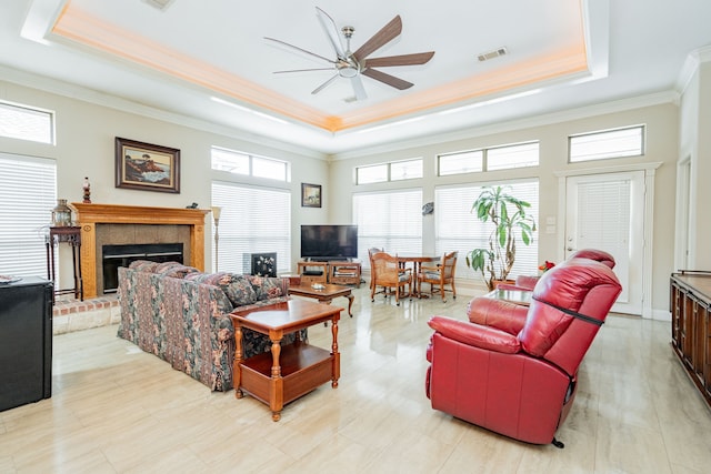 120 Saint Francis Ln, Mabank, TX 75156 - living area with a tray ceiling, ceiling fan, crown molding, and a tile fireplace