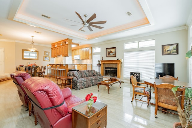 120 Saint Francis Ln, Mabank, TX 75156 - living area with a raised ceiling, a ceiling fan, a fireplace with raised hearth, crown molding, and healthy amount of natural light