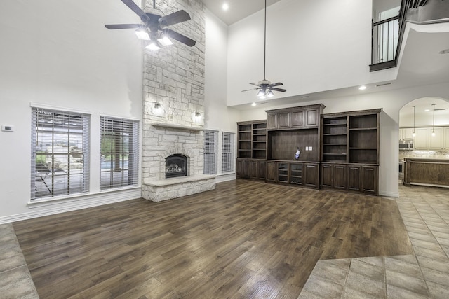 124 Fm 2450, Krum, TX 76249 - unfurnished living room featuring a high ceiling, a ceiling fan, wood finished floors, a fireplace, and baseboards