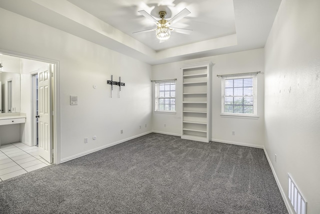 124 Fm 2450, Krum, TX 76249 - unfurnished bedroom with carpet floors, baseboards, a tray ceiling, a ceiling fan, and connected bathroom