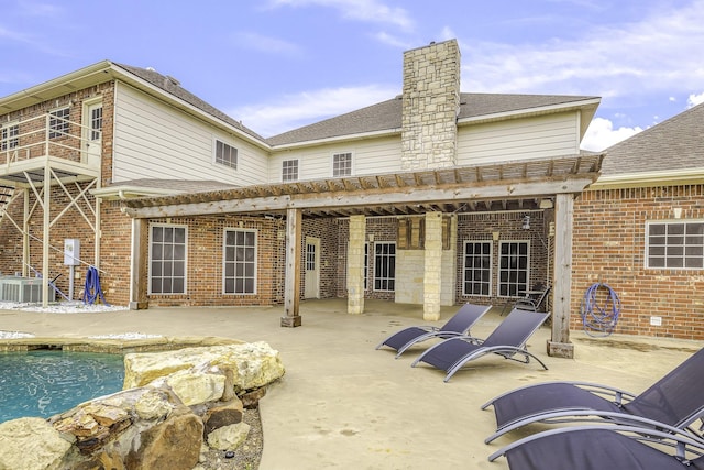 124 Fm 2450, Krum, TX 76249 - rear view of house with a patio, central AC, a chimney, brick siding, and an outdoor pool