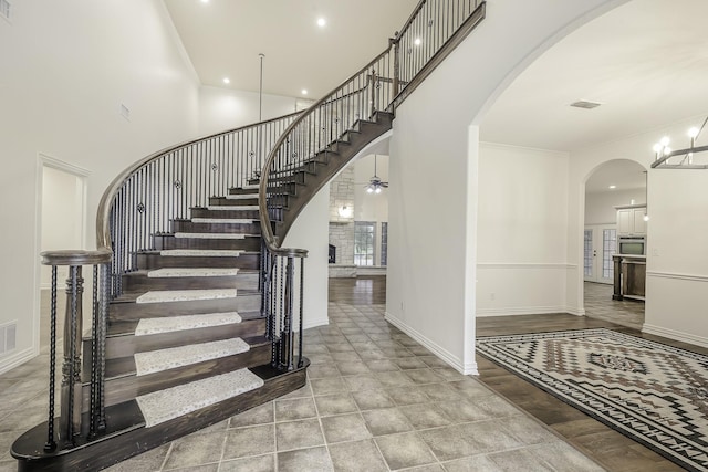 124 Fm 2450, Krum, TX 76249 - staircase with arched walkways, baseboards, a towering ceiling, and a chandelier