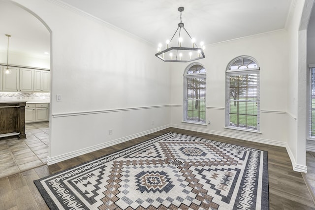 124 Fm 2450, Krum, TX 76249 - unfurnished dining area featuring arched walkways, wood finished floors, ornamental molding, a chandelier, and baseboards
