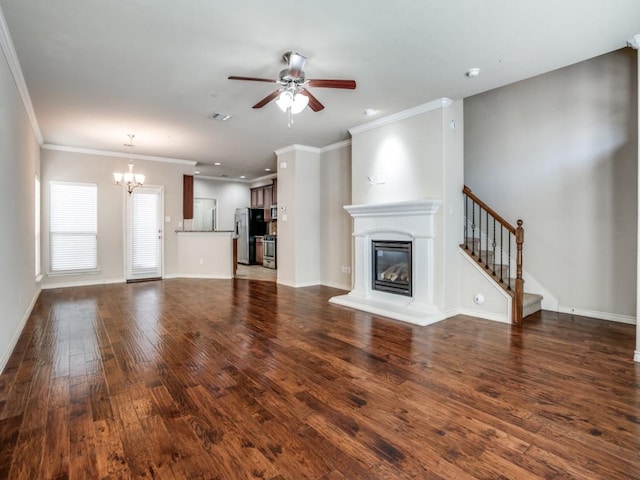 8808 Papa Trl, Mckinney, TX 75070 - unfurnished living room with a chandelier, a glass covered fireplace, a ceiling fan, wood finished floors, and crown molding