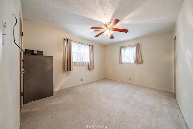 2302 13th, Brownwood, TX 76801 - spare room with ceiling fan, carpet flooring, healthy amount of natural light, and a textured ceiling