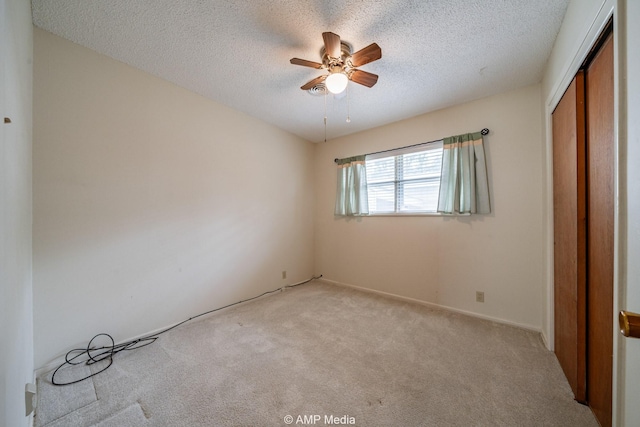 2302 13th, Brownwood, TX 76801 - unfurnished bedroom with light colored carpet, a closet, a textured ceiling, and a ceiling fan