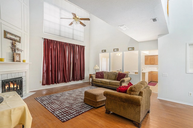 6204 Pennsylvania Ave, Arlington, TX 76017 - living area featuring high vaulted ceiling, ceiling fan, a tiled fireplace, and light wood-style flooring