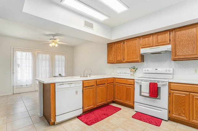 6204 Pennsylvania Ave, Arlington, TX 76017 - kitchen with white appliances, under cabinet range hood, a peninsula, and brown cabinetry