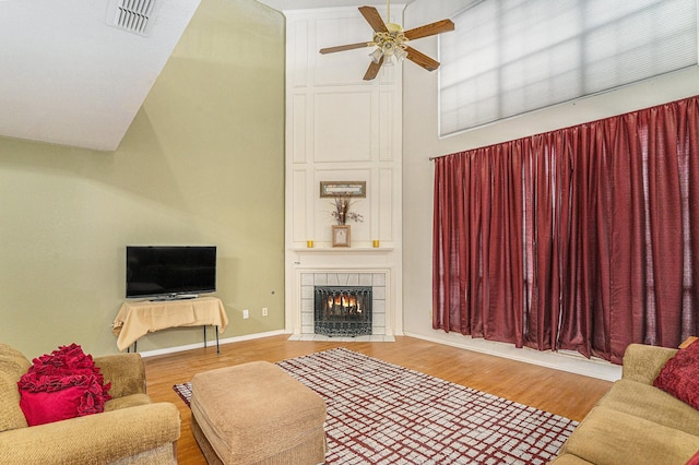 6204 Pennsylvania Ave, Arlington, TX 76017 - living room featuring a ceiling fan, wood finished floors, a fireplace, and a towering ceiling