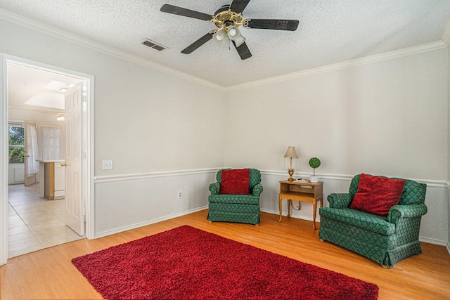 6204 Pennsylvania Ave, Arlington, TX 76017 - living area with wood finished floors, a ceiling fan, a textured ceiling, and ornamental molding