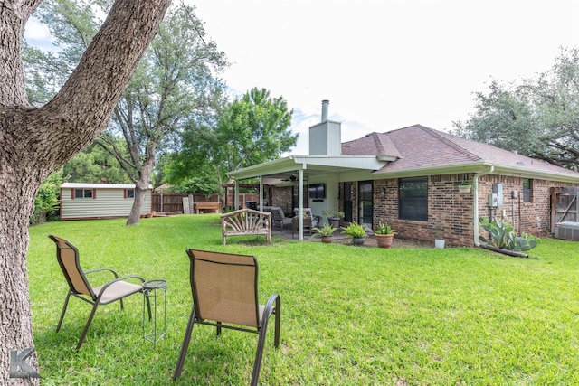 1626 Morrow Ln, Abilene, TX 79601 - back of property with a ceiling fan, a chimney, brick siding, a shingled roof, and a patio