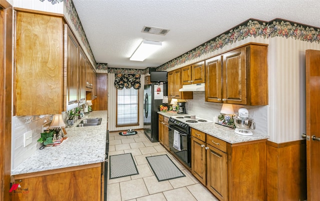 9507 Chapparral Ln, Shreveport, LA 71118 - kitchen with black appliances, under cabinet range hood, a textured ceiling, brown cabinets, and a sink