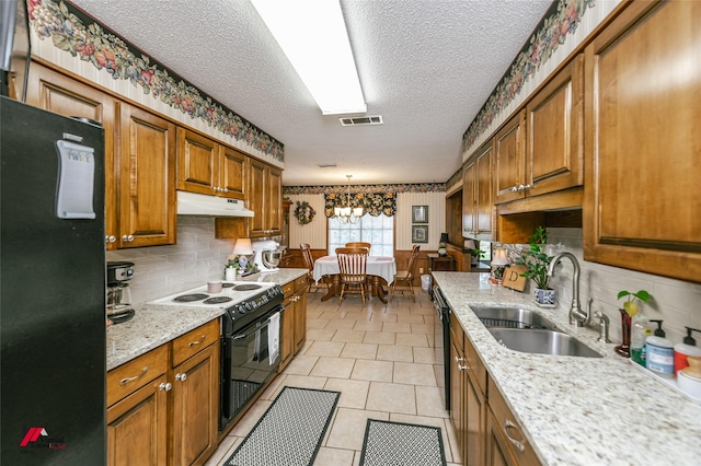 9507 Chapparral Ln, Shreveport, LA 71118 - kitchen with black appliances, a sink, under cabinet range hood, a textured ceiling, and brown cabinets
