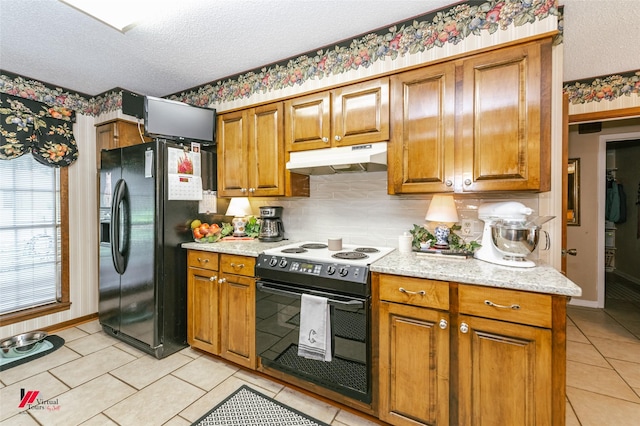 9507 Chapparral Ln, Shreveport, LA 71118 - kitchen featuring black appliances, a textured ceiling, under cabinet range hood, brown cabinetry, and light tile patterned floors