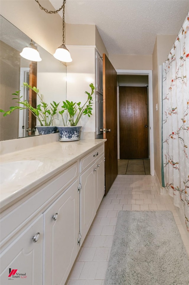 9507 Chapparral Ln, Shreveport, LA 71118 - bathroom featuring tile patterned floors, vanity, and a textured ceiling