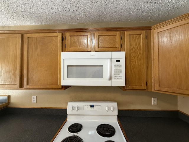 1420 Alta Mesa Ct, Mesquite, TX 75150 - kitchen view of white appliances, brown cabinetry, a textured ceiling, and dark countertops
