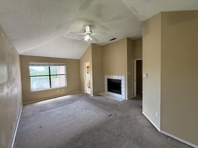 1420 Alta Mesa Ct, Mesquite, TX 75150 - unfurnished living room with a textured ceiling, a ceiling fan, carpet floors, lofted ceiling, and a tiled fireplace