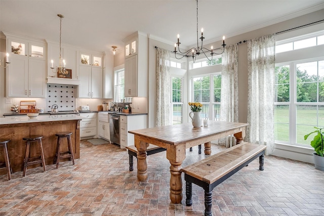 182 Hcr 1431, Covington, TX 76636 - dining area featuring a chandelier, brick flooring, healthy amount of natural light, and ornamental molding
