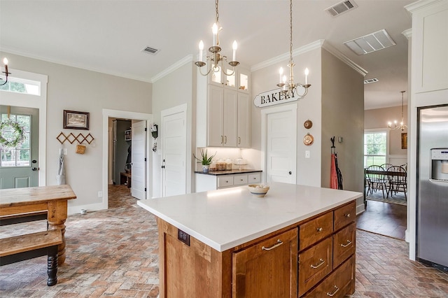182 Hcr 1431, Covington, TX 76636 - kitchen with a chandelier, crown molding, brick flooring, white cabinetry, and a center island
