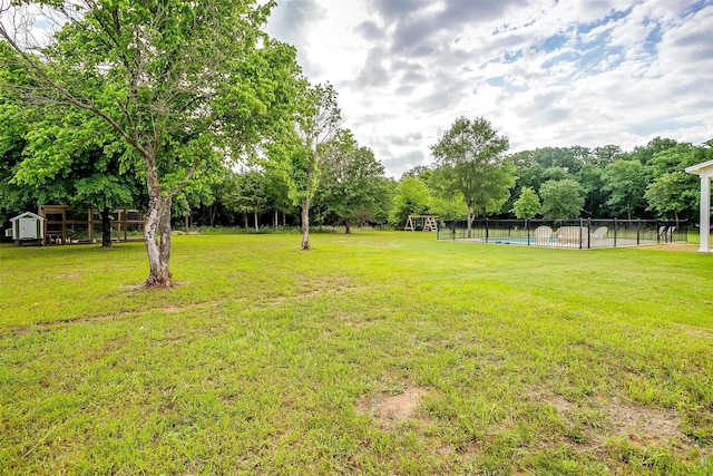 182 Hcr 1431, Covington, TX 76636 - view of yard featuring an outdoor pool, a storage shed, view of wooded area, and an outdoor structure
