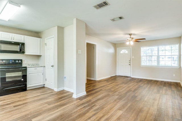 4312 Ridgedale Dr, Mesquite, TX 75150 - kitchen featuring black appliances, light wood finished floors, and white cabinets