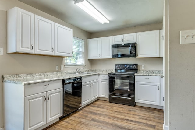 4312 Ridgedale Dr, Mesquite, TX 75150 - kitchen featuring black appliances, white cabinetry, light wood-type flooring, a sink, and light countertops