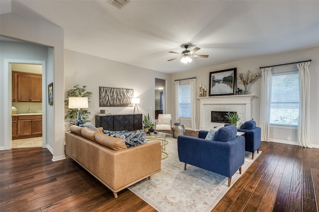 5924 Deerwood Ln, Frisco, TX 75036 - living area with dark wood-style flooring, ceiling fan, baseboards, and a fireplace