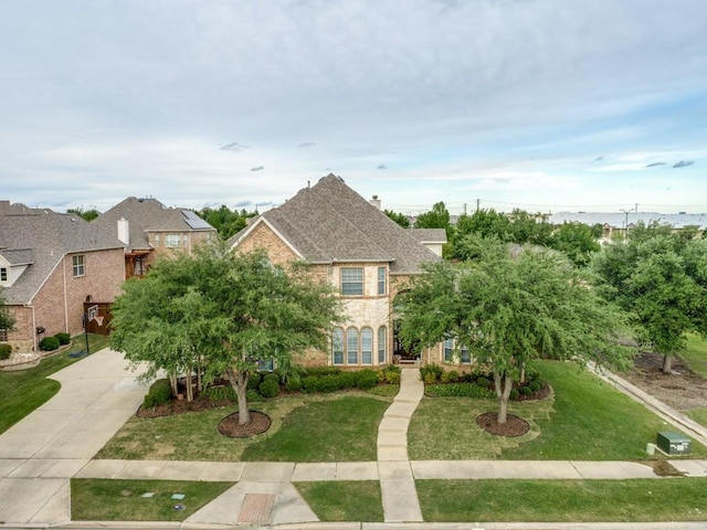 5924 Deerwood Ln, Frisco, TX 75036 - view of front of home featuring concrete driveway, a front yard, stone siding, and brick siding