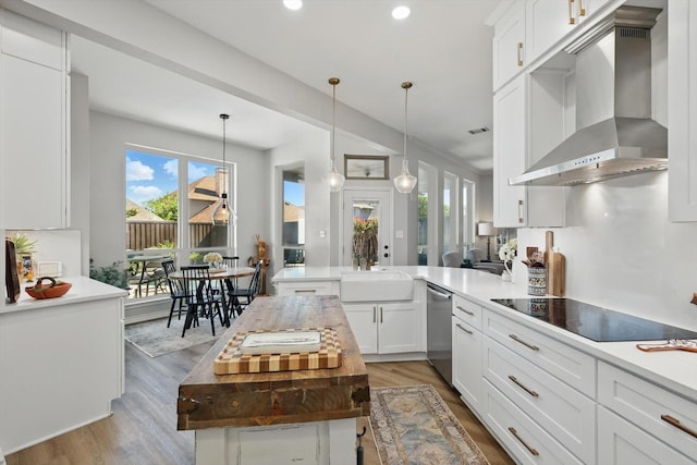 3921 Overlake Dr, Plano, TX 75023 - kitchen with wall chimney range hood, a sink, a peninsula, plenty of natural light, and recessed lighting