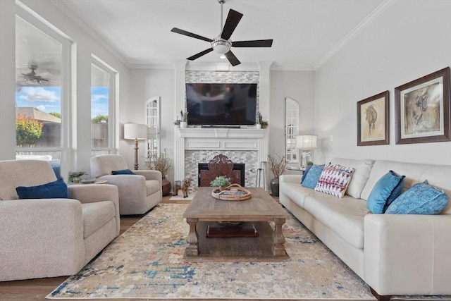 3921 Overlake Dr, Plano, TX 75023 - living room featuring ceiling fan, ornamental molding, wood finished floors, and a stone fireplace