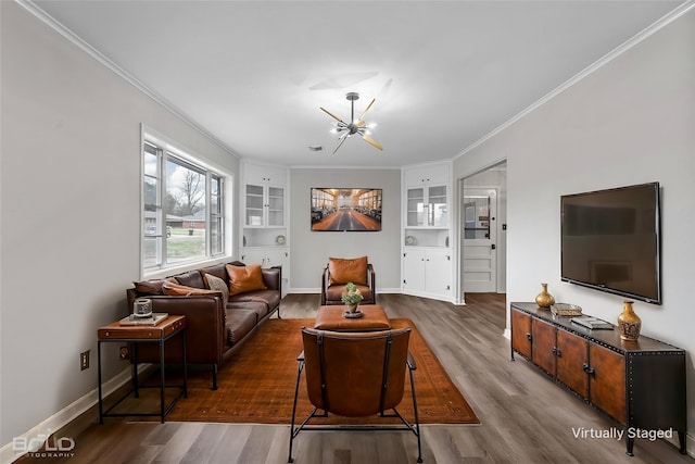 living room with a chandelier, ornamental molding, wood finished floors, built in shelves, and baseboards