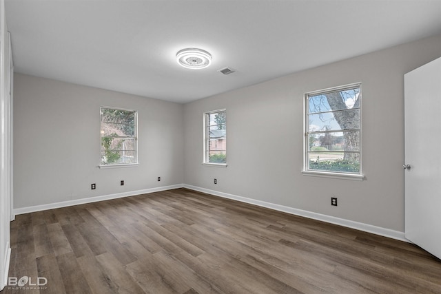 unfurnished room with dark wood-style flooring and baseboards
